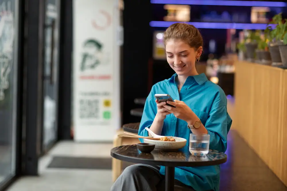 happy-woman-in-a-restaurant-on-her-phone